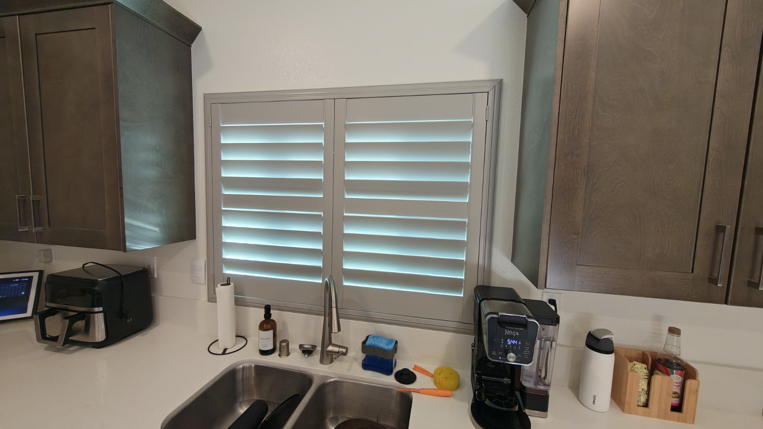 Custom plantation shutters installed over a kitchen sink window