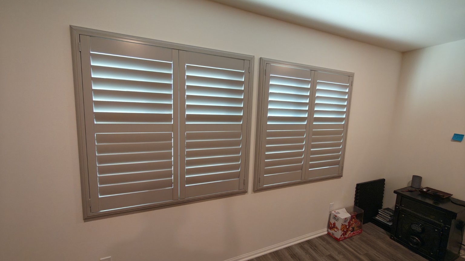 Custom plantation shutters installed across two living-room windows