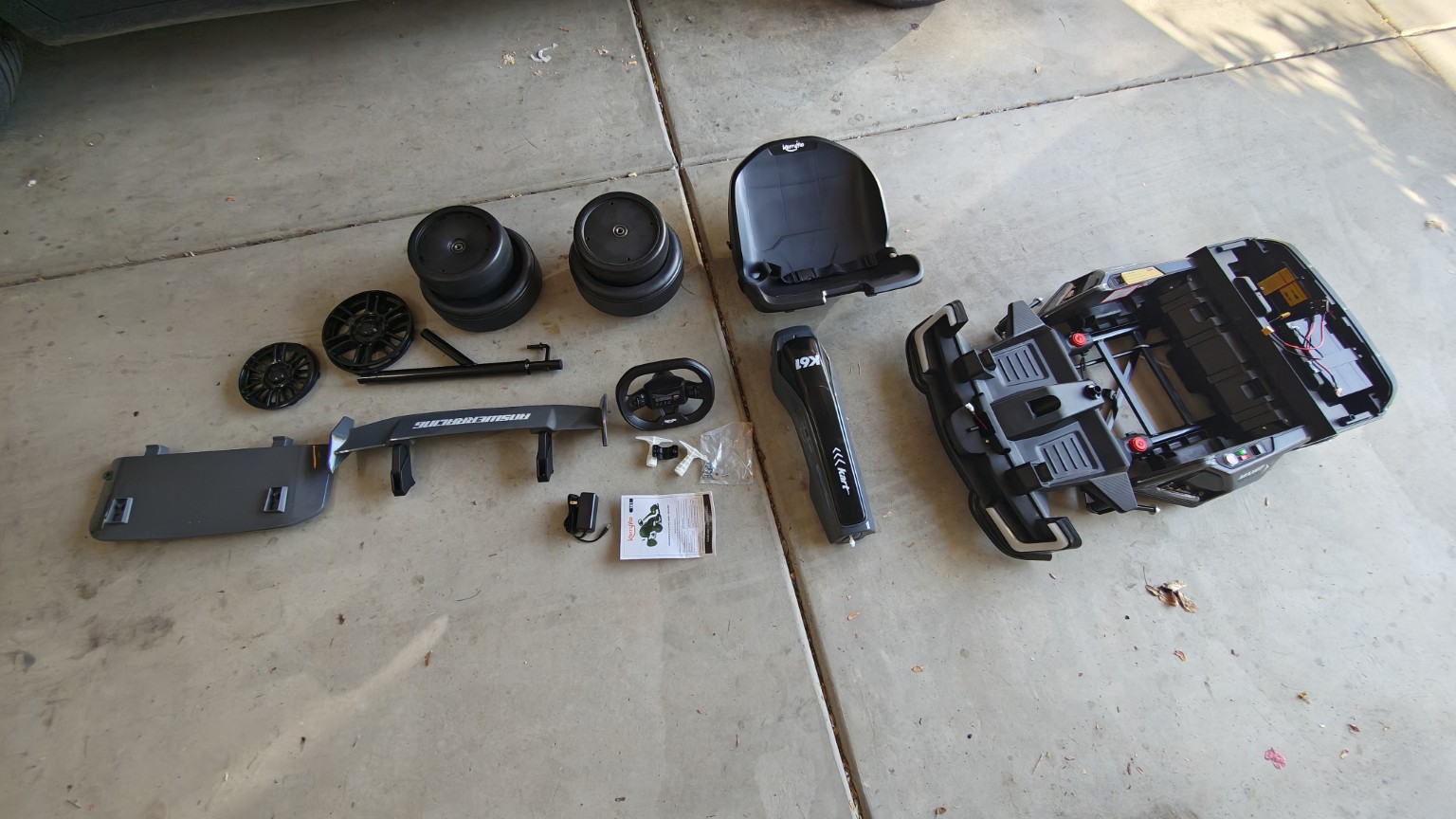 Gray electric drift cart laid out in parts before assembly