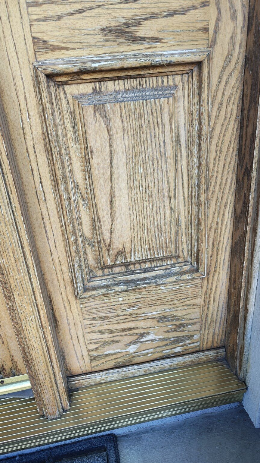 Close view of sun and water damage on the lower oak door panel