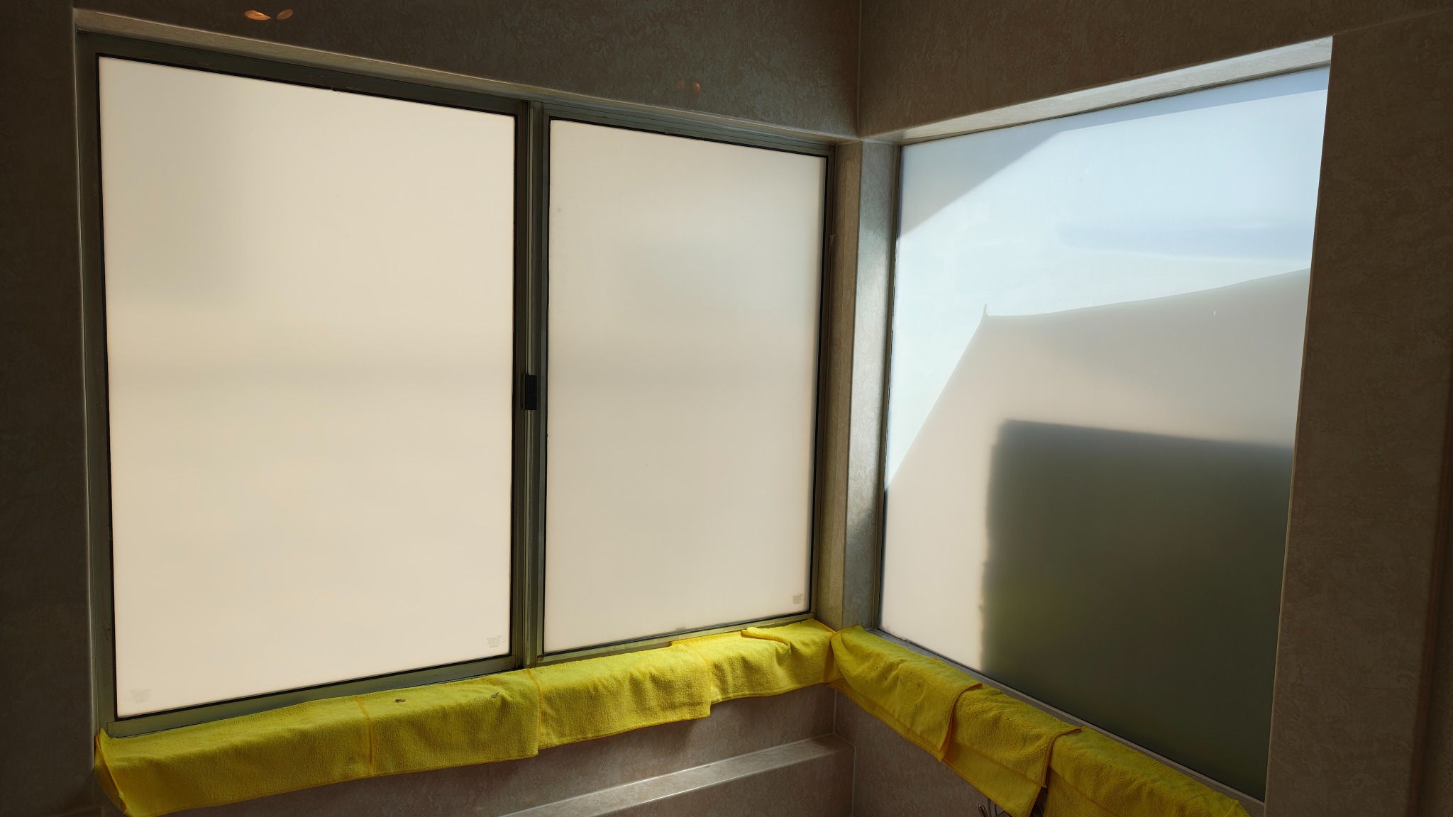Three master bathroom windows after frosted privacy film installation